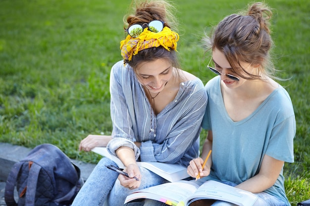 Free photo female friends studying together in park