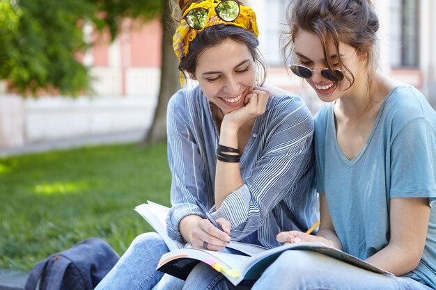 Female friends studying together in park