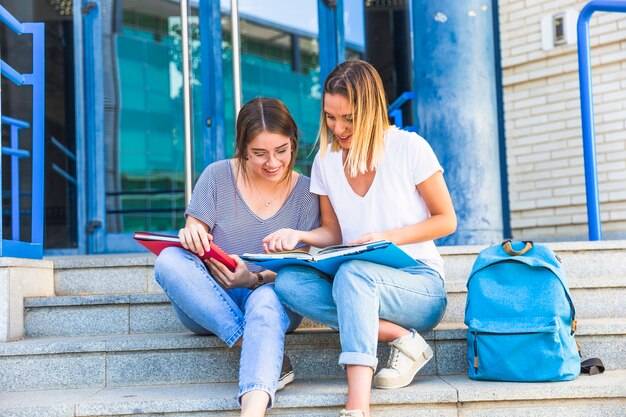 Female friends studying on university steps