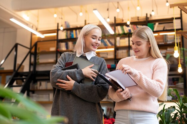 図書館から本を取り、勉強会で使う女友達