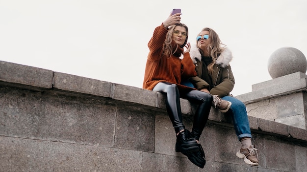 Female friends taking selfie outdoors