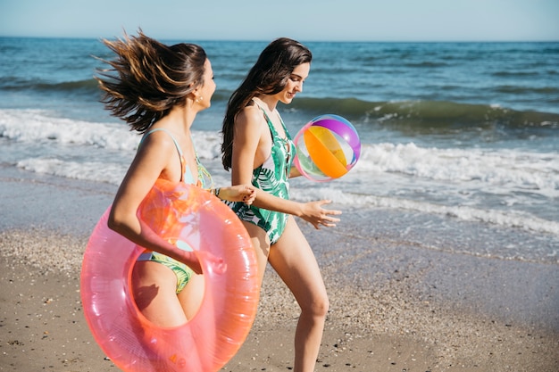 Foto gratuita amici femminili che camminano sulla spiaggia