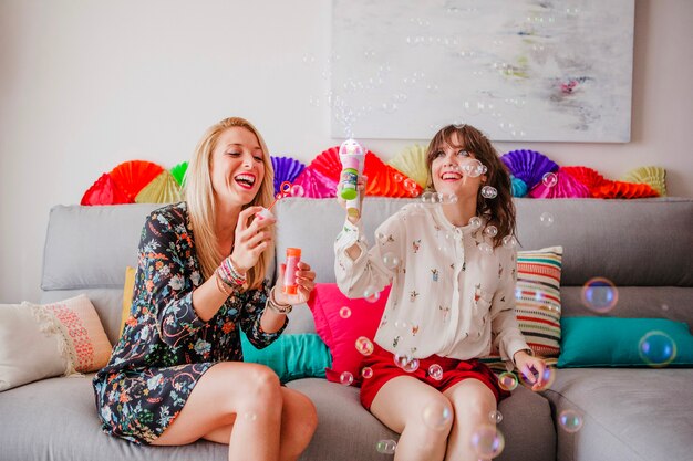 Female friends with soap bubbles