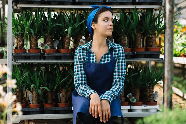 Female gardener sitting in front of potted plants