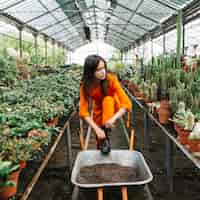 Free photo female gardener wearing wellington boot in greenhouse