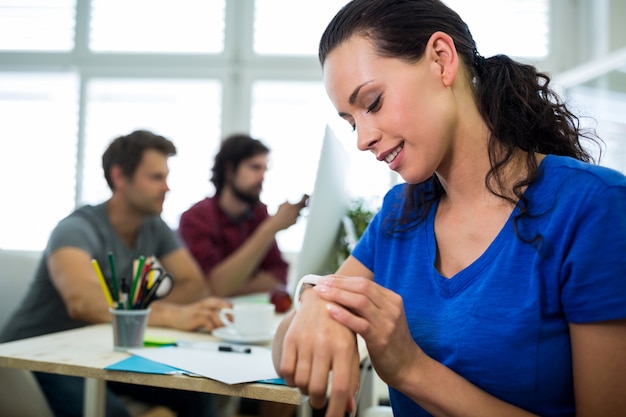 Foto gratuita femmina graphic designer tempo sul smartwatch controllo