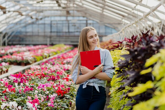 Female in greenhouse with clipboard