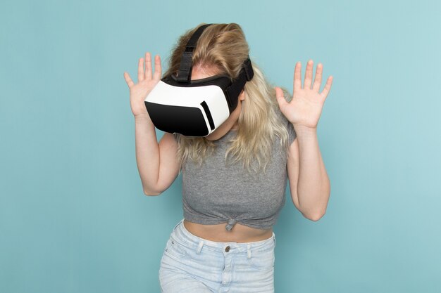 female in grey shirt and bright blue jeans playing vr