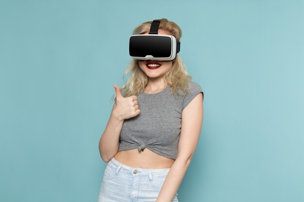 灰色のシャツと明るいブルージーンズの女性がvrを再生