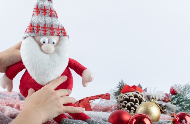 Female hand Christmas Santa figurine on white surface