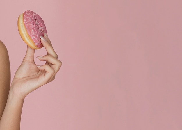 Female hand holding an appetizing donut