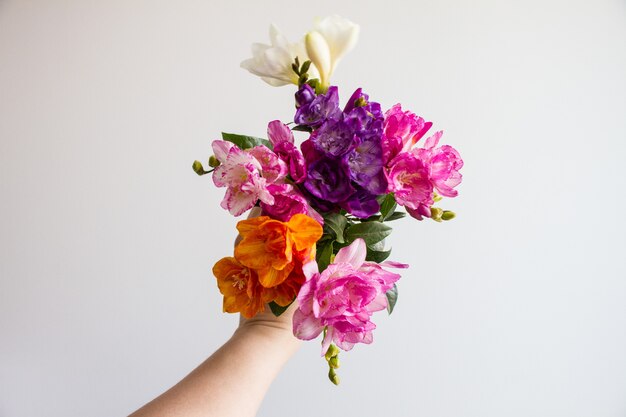 Female hand holding a beautiful colorful flower bouquet