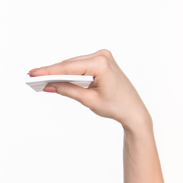 Female hand holding blank paper for records on white.