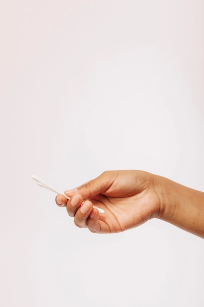 Female hand holding cotton swabs