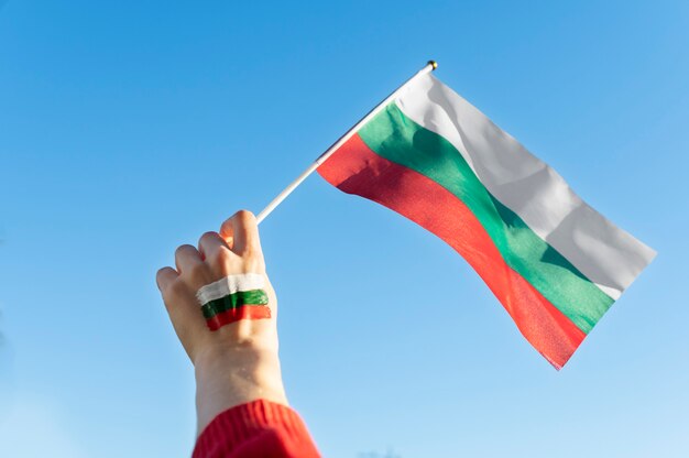 Female hand holding fabric flag of bulgaria