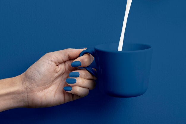 Female hand holding milk cup