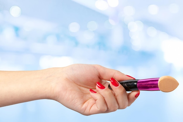 Free photo female hand holding a professional makeup brush