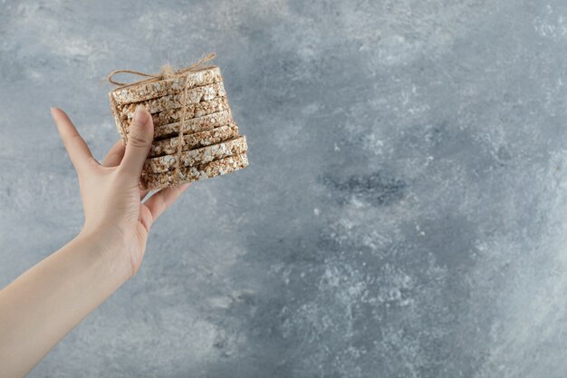 Female hand holding stack of delicious crispbread