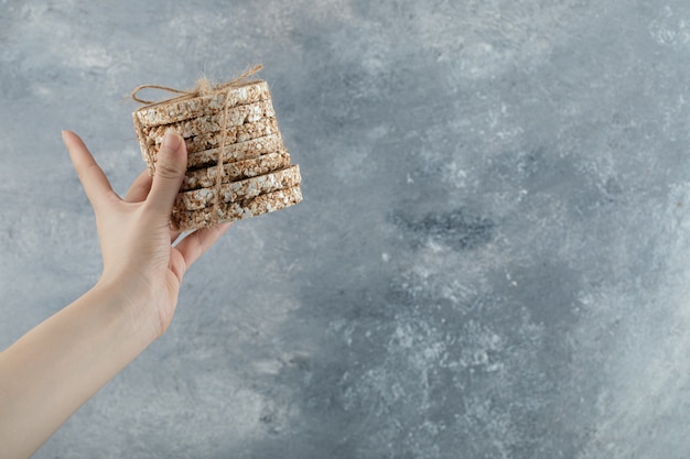 Female hand holding stack of delicious crispbread