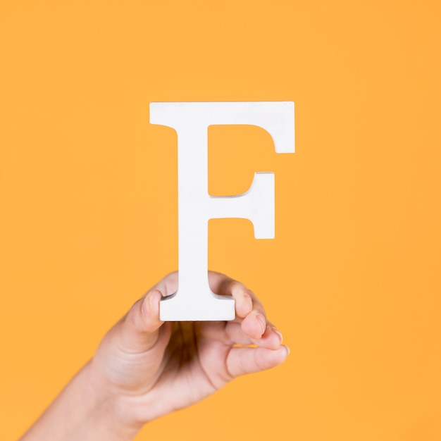 Female hand holding up the uppercase capital letter f