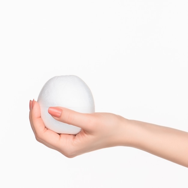 The female hand holding white blank styrofoam oval