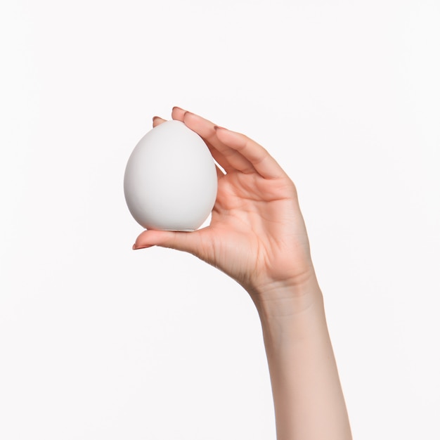female hand holding white blank styrofoam oval