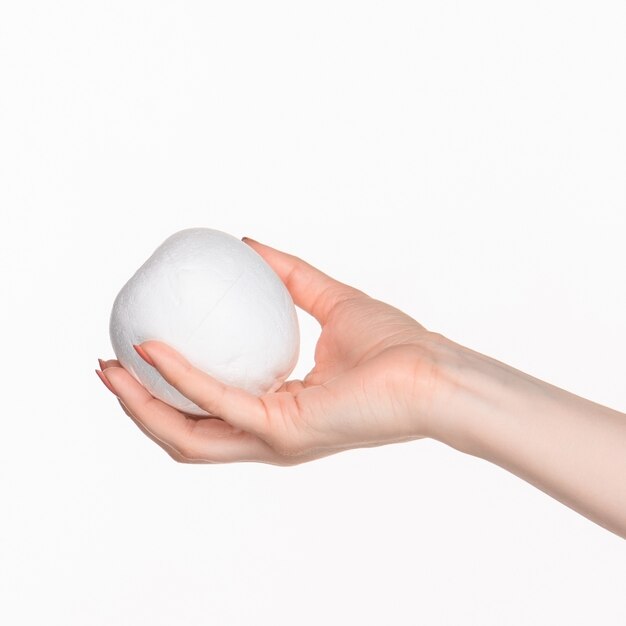female hand holding white blank styrofoam oval