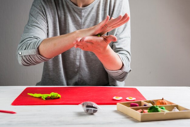 Female hand kneading clay for making craft