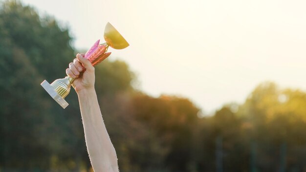 Female hand raising a trophy