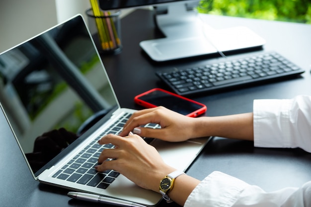 Foto gratuita mano femminile che scrive sulla tastiera del computer portatile