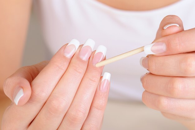 Female hand  with a cosmetic stick for  cleaning cuticle