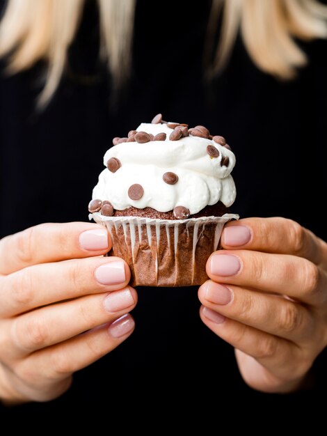 Female hands holding delicious muffin