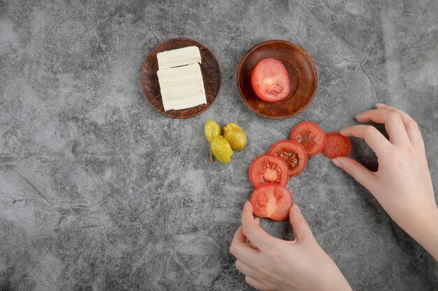 여성 손 돌 배경에 신선한 토마토를 들고입니다.