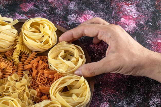 Female hands holding pasta nest from plate.