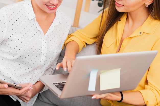 Female hands holding a phone and laptop