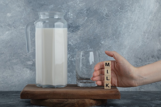 Female hands holding wooden letters with fresh milk.