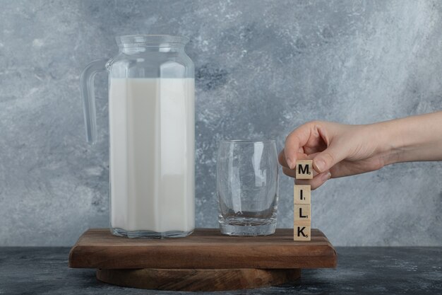 Female hands holding wooden letters with fresh milk.