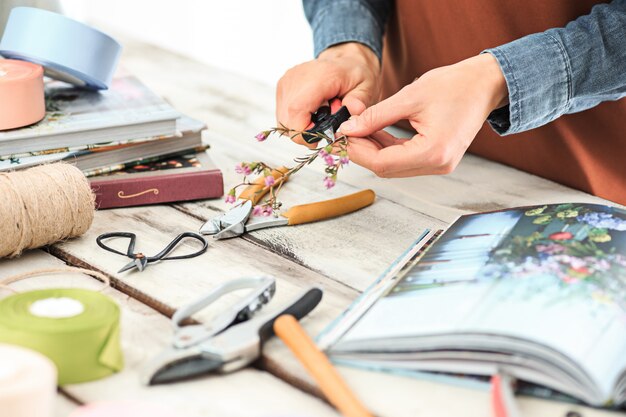 female hands making bouquet of different flowers