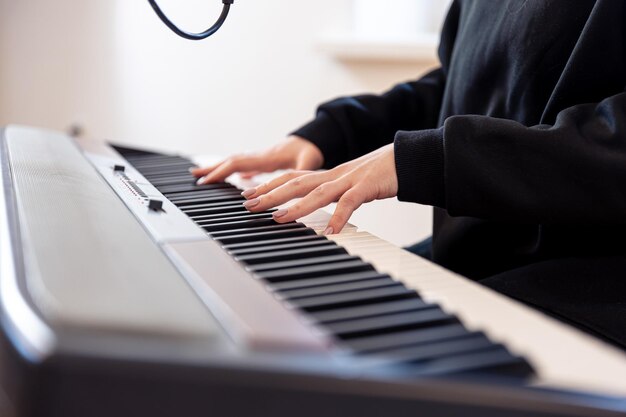 Женские руки играют музыкальные клавиши мягкий фокус