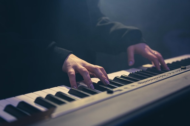 Free photo female hands play musical keys soft focus