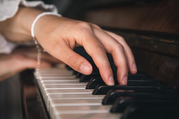 Free photo female hands playing the old piano closeup