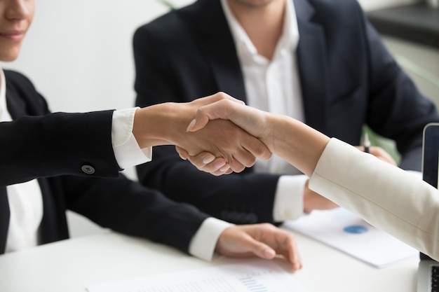 Female hands shaking at group meeting making partnership deal, closeup