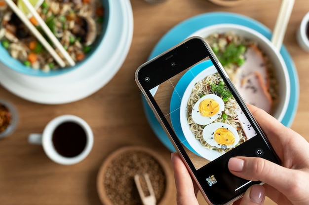 Female hands taking photo of a bowl of ramen