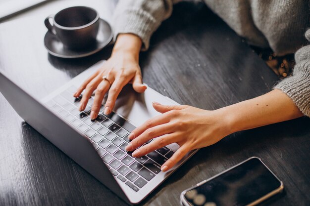 コンピューターのキーボードで入力する女性の手