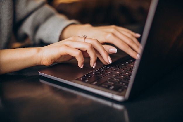コンピューターのキーボードで入力する女性の手