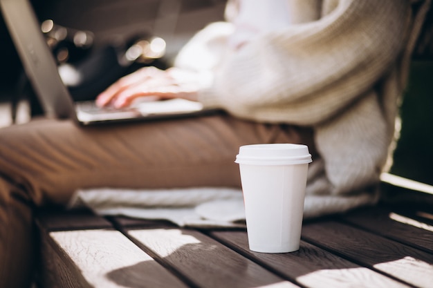 無料写真 フォーカスのコーヒーカップとラップトップに入力する女性の手