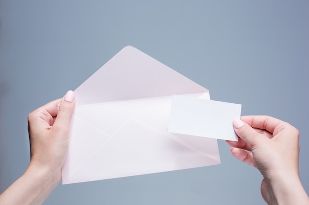 The female hands with envelope against the gray space