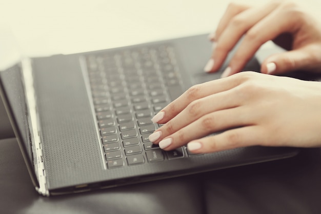 Female hands with fingers over laptop keyboard
