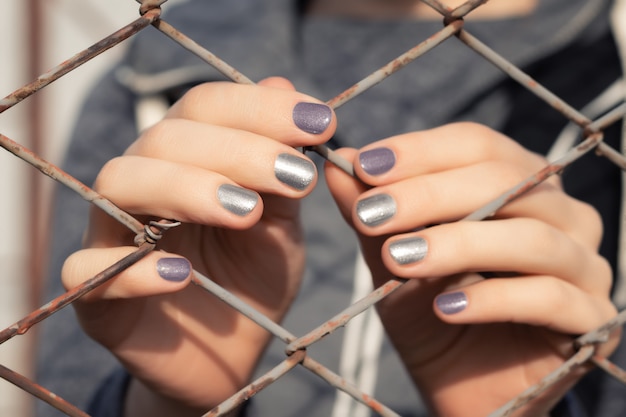 Женские руки с серым блеском дизайна ногтей.