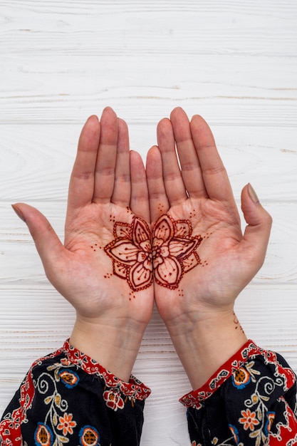 Female hands with mehndi on table